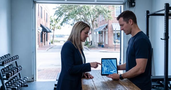Two people looking at a tablet with a map in a gym