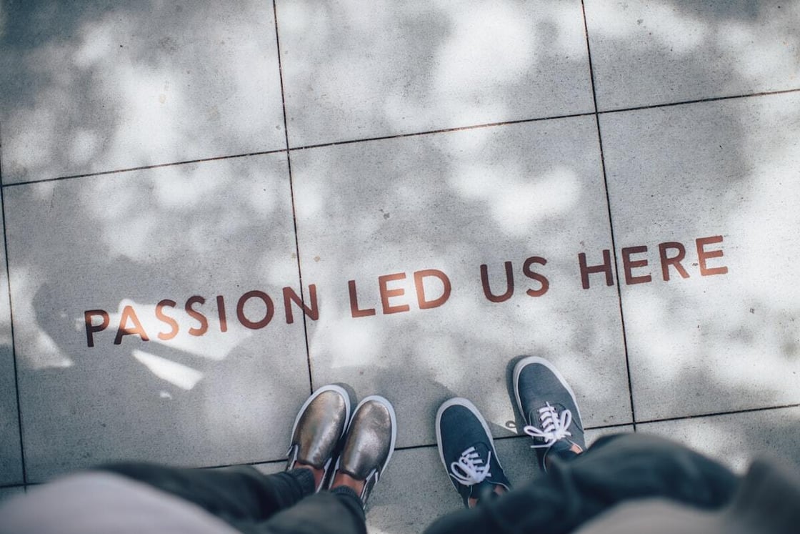Shoes beside the words Passion Led Us Here on a walkway