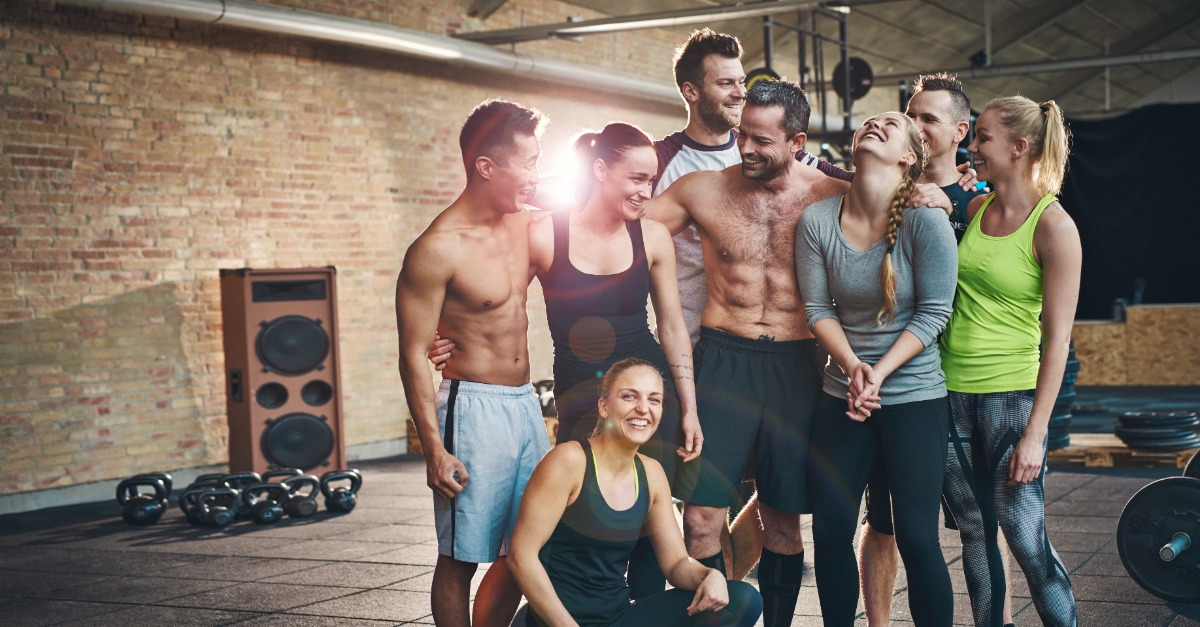 Group in workout clothing posing together in a gym